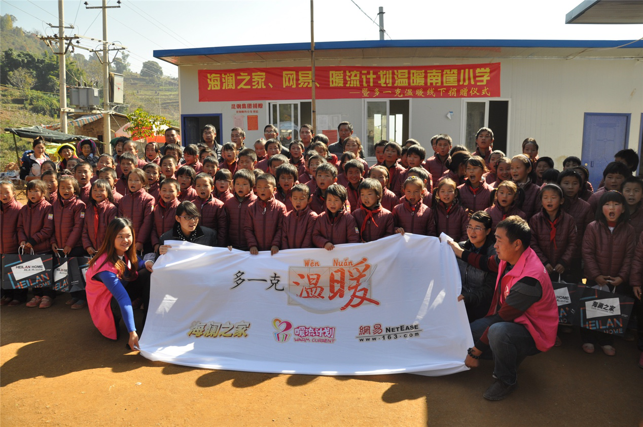 2014年11月20日，“多一克溫暖”公益團隊來到8.3大地震的重災區(qū)——云南省昭通市魯甸縣的南筐小學。越過崎嶇山路，將一批又一批暖心羽絨服送到了師生們的手中，也將社會的關懷和愛意傳遞給了這些可愛的人。