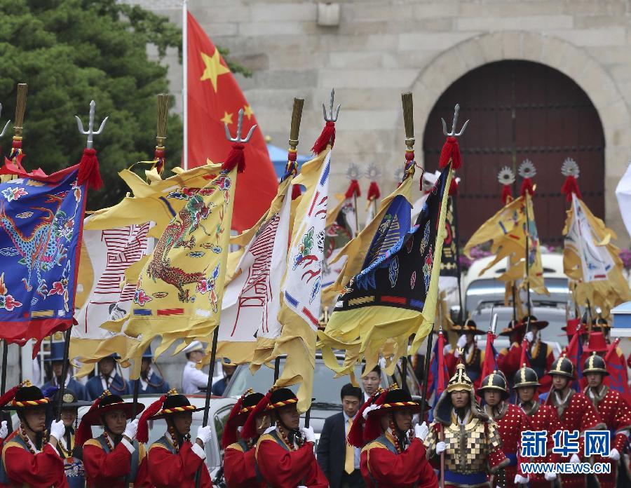 7月3日，韓國總統(tǒng)樸槿惠在青瓦臺總統(tǒng)府舉行隆重儀式，歡迎中國國家主席習(xí)近平對韓國進(jìn)行國事訪問。這是習(xí)近平的車隊(duì)在身著民族服裝的韓國禮儀隊(duì)伍引導(dǎo)下駛?cè)肭嗤吲_。新華社記者丁林?jǐn)z  